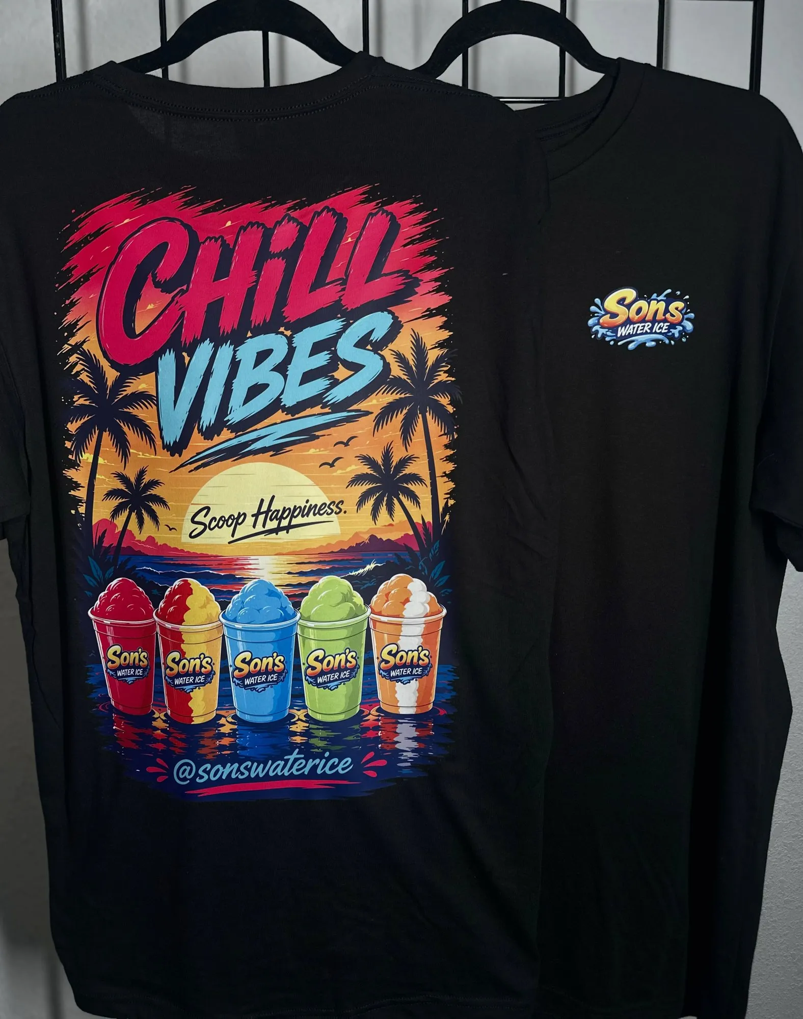 Two black t-shirts for Son's Water Ice, one showing a full-color sunset back print, the other a small chest logo