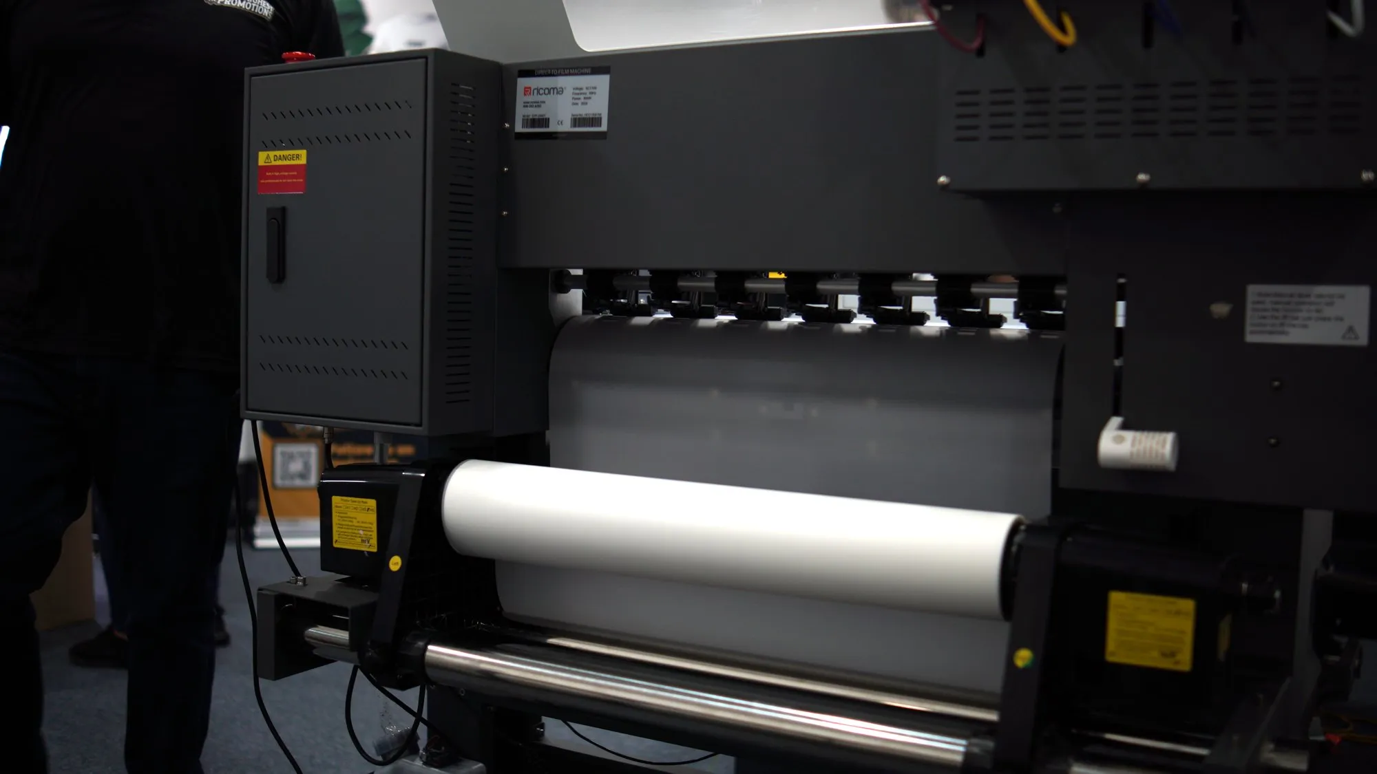 DTF printer in the 4 His Highest Promotions shop with a roll of transfer film loaded